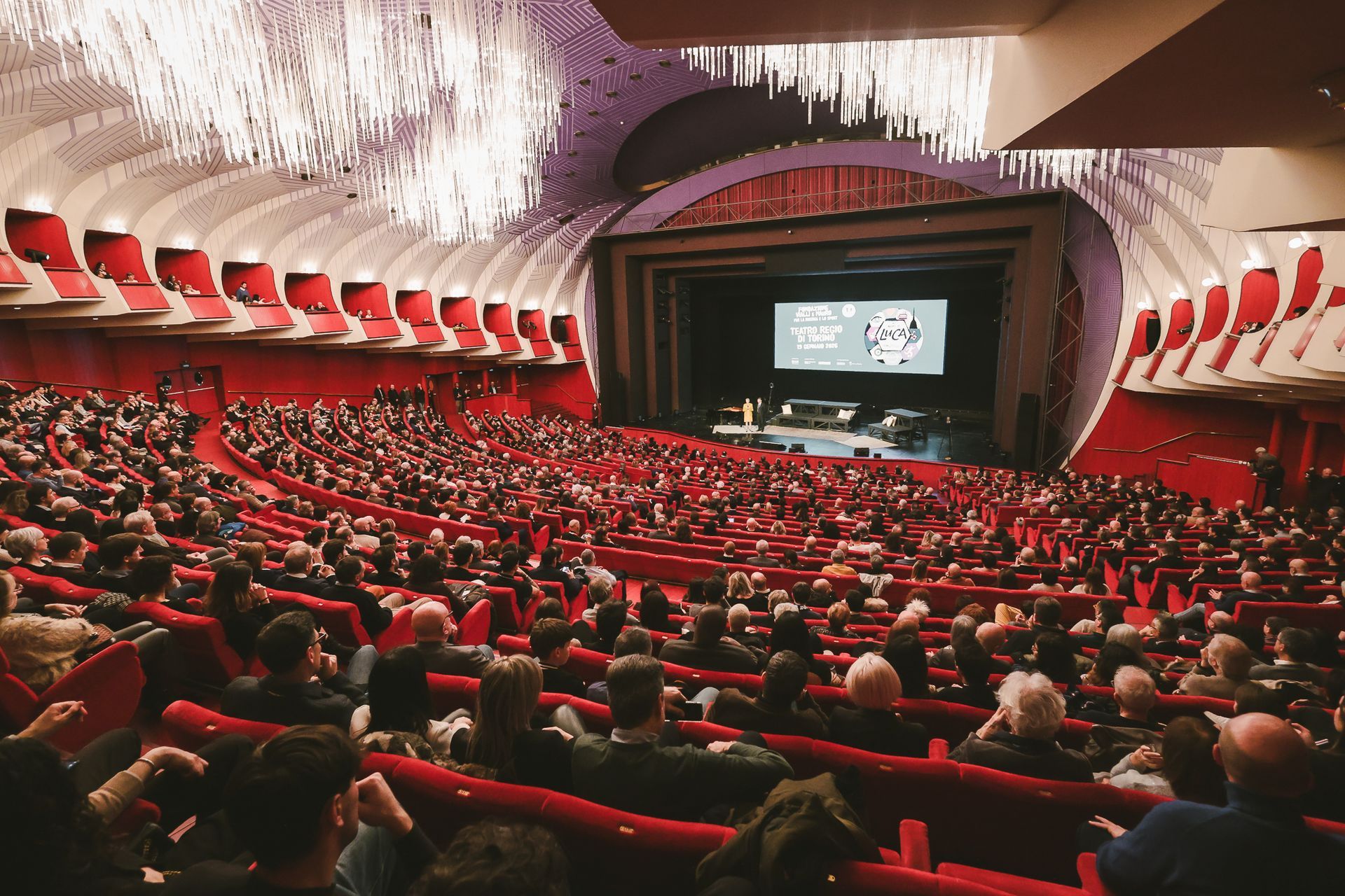 Gruppo di uomini in posa per una foto su un prato, alberi sullo sfondo, camicie bianche e nere, ritratto.