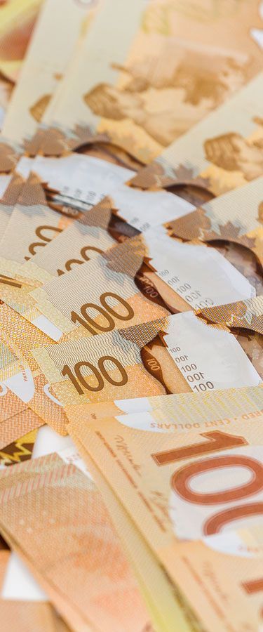 A close up of a pile of canadian dollars on a table.