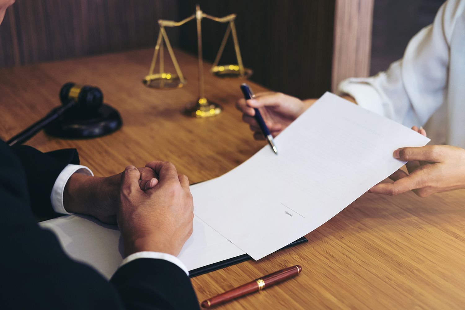 Client agreement signing, highlighting criminal lawyer professionalism and client support.