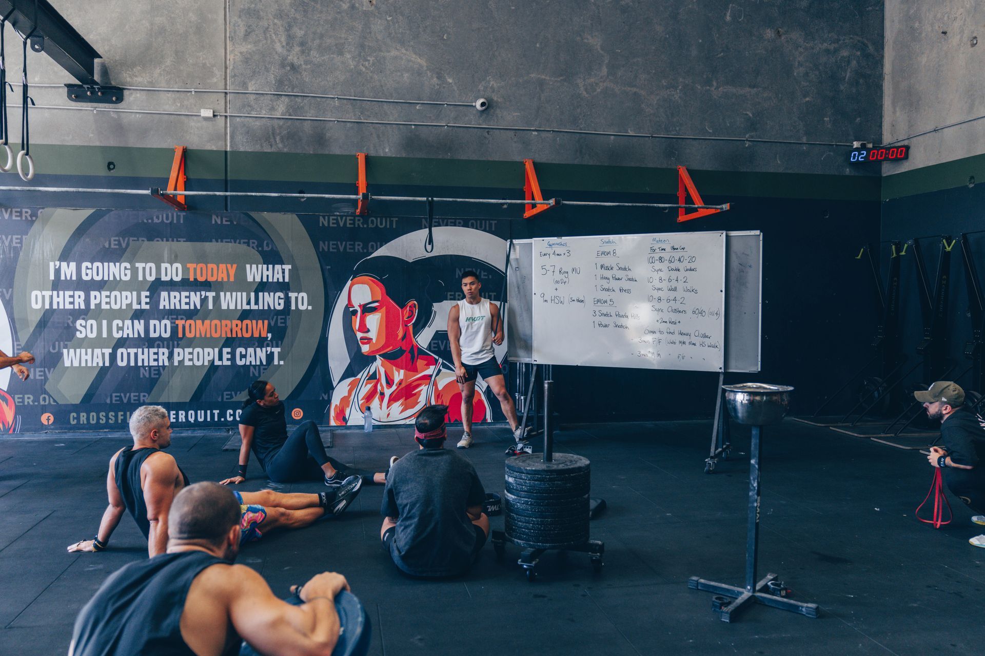 A group of people are doing stretching exercises in a gym.