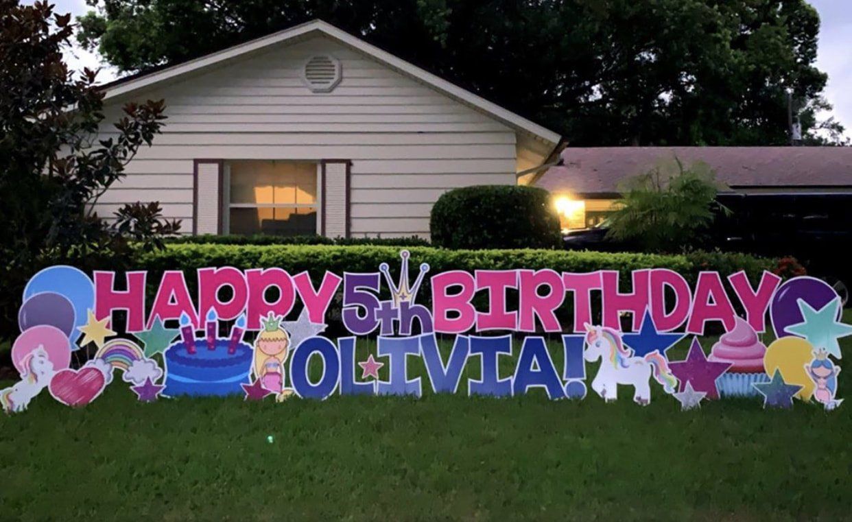 A happy 5th birthday sign in front of a house