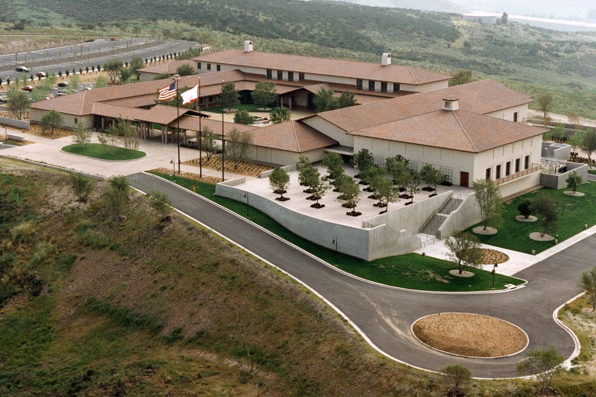 An aerial view of a large building with a roundabout in front of it