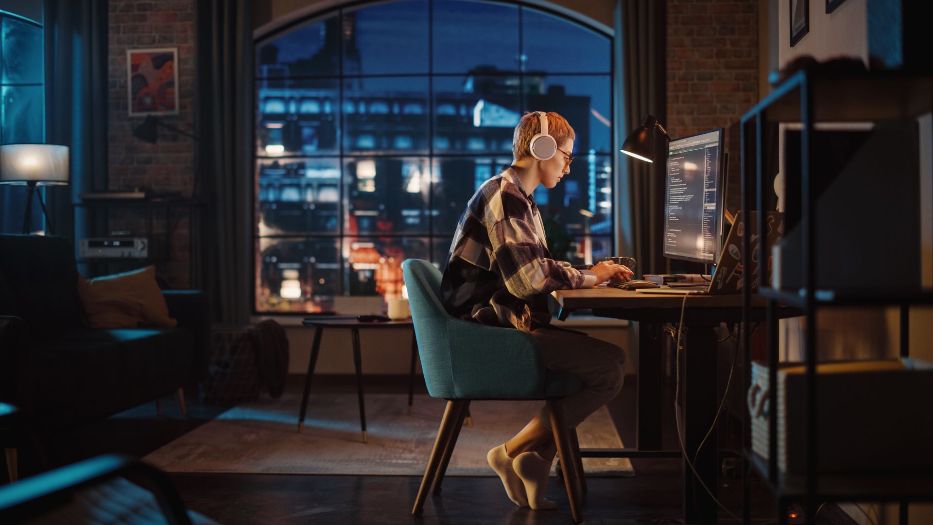 A man is sitting at a desk in front of a computer.