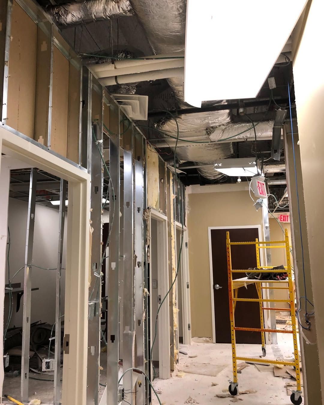 A hallway in a building under construction with a scaffolding in the middle.
