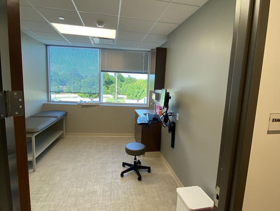A doctor 's office with a stool and a table