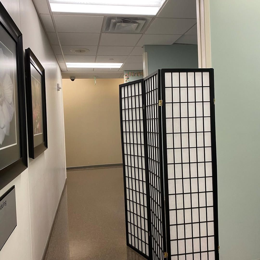 A long hallway with a room divider in the middle of it.