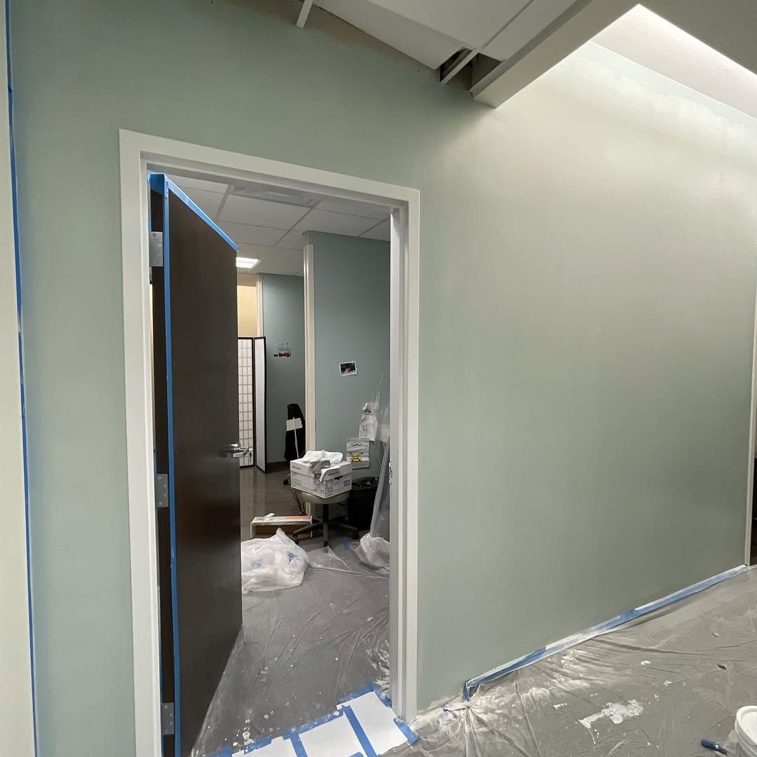 A door is open in a room that is being painted