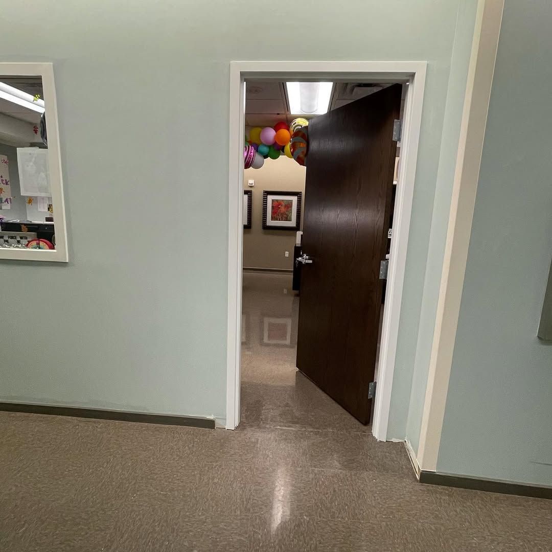 A doorway leading to a room with balloons hanging from the ceiling.