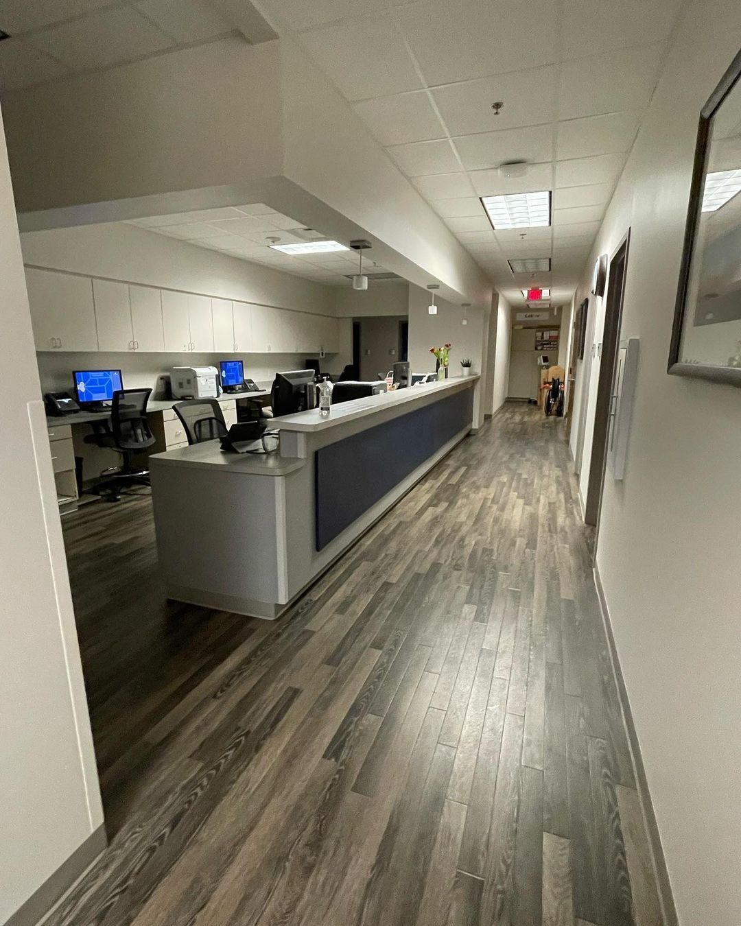 A long hallway with a desk in the middle of it.