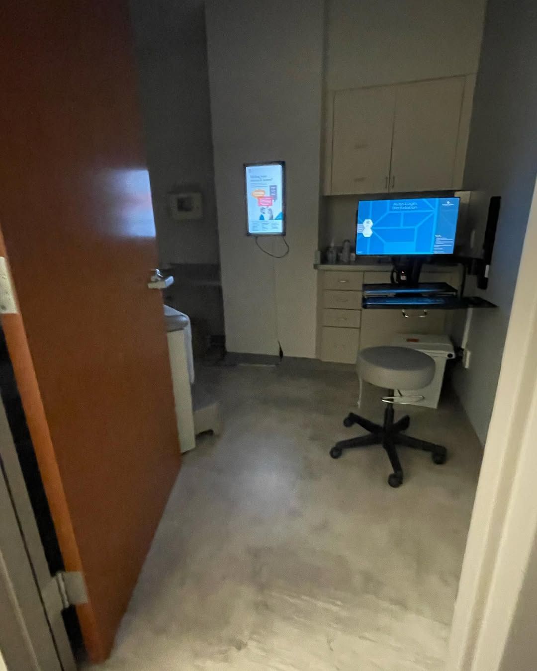 A room with a computer and a stool in it