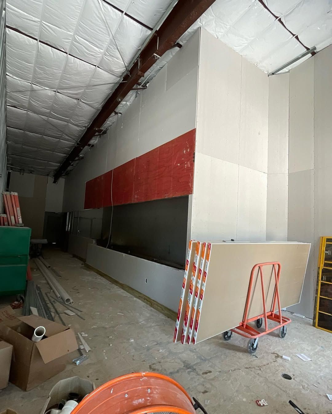 A building under construction with boxes and a cart