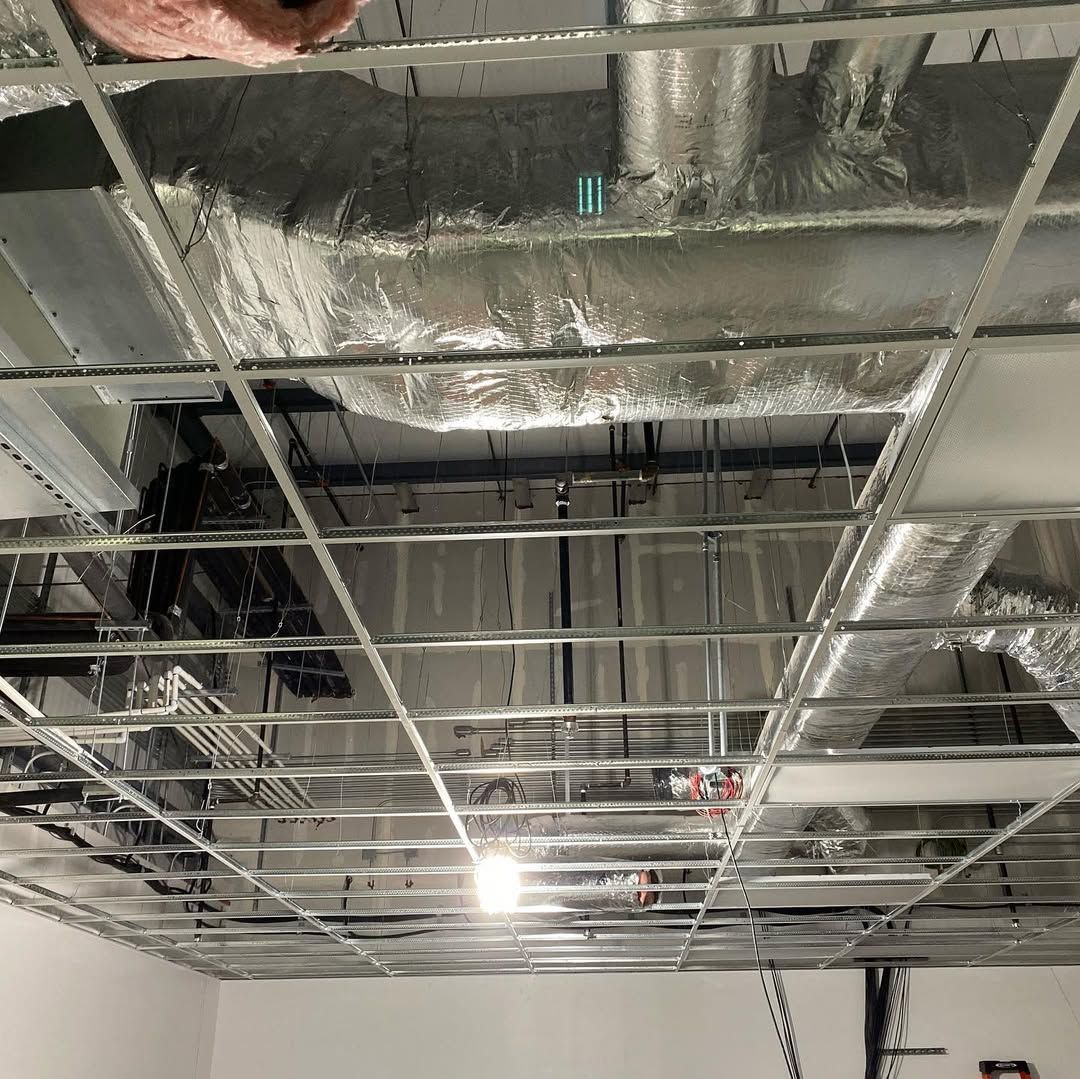 A ceiling with a lot of pipes hanging from it.