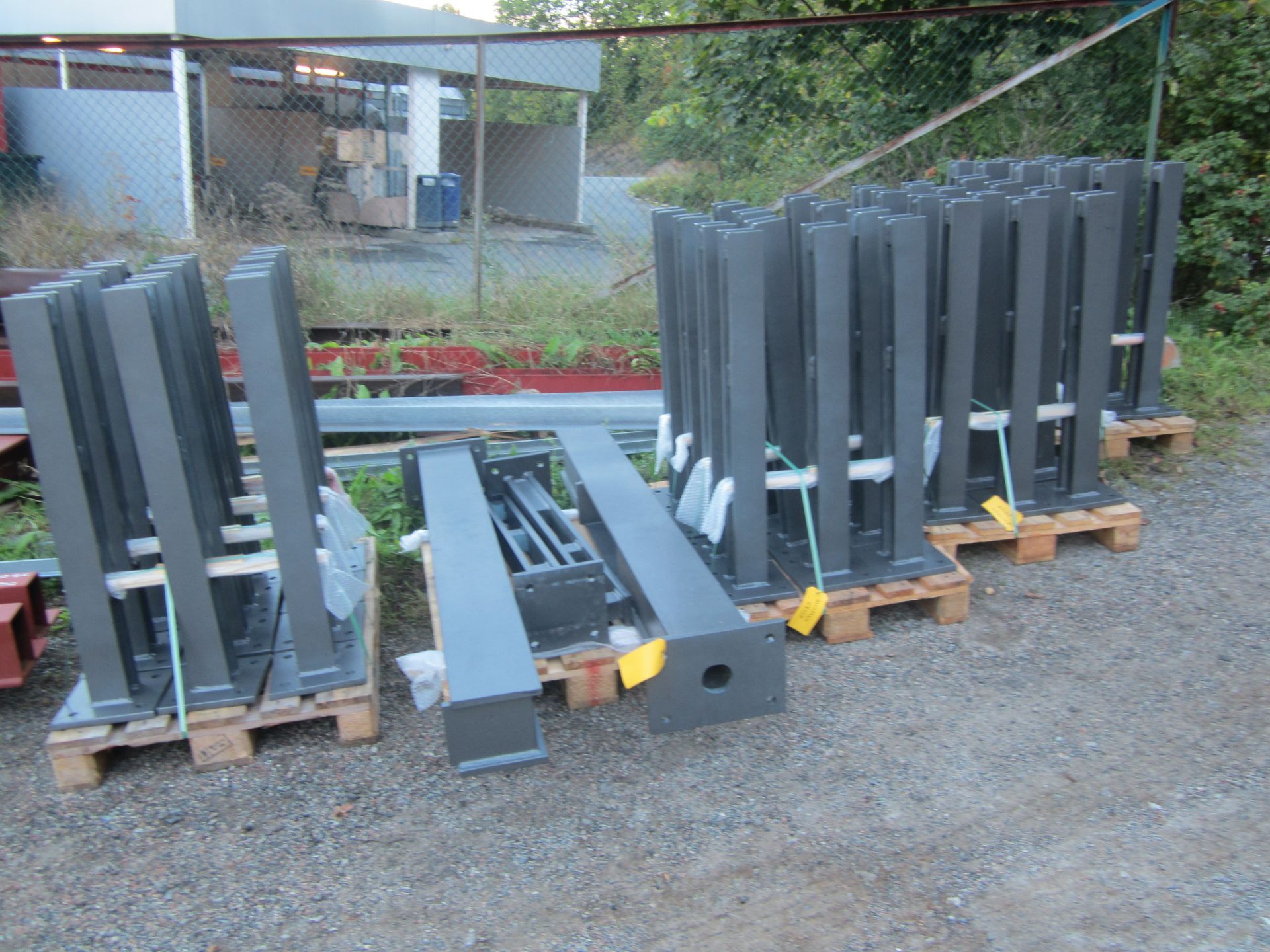 Stabler med grå metallstenger på paller, utendørs.