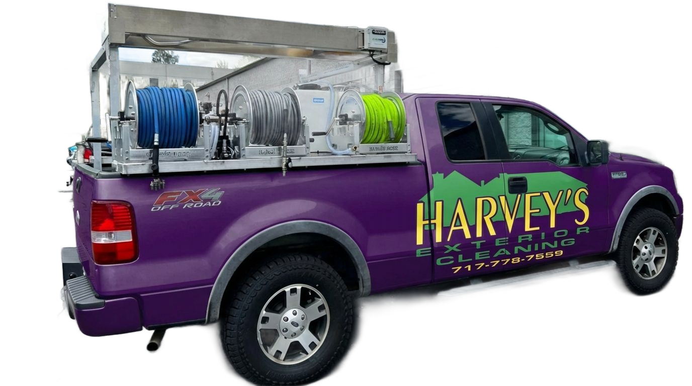 Purple truck with Harvey's Exterior Cleaning logo, carrying pressure washing equipment.