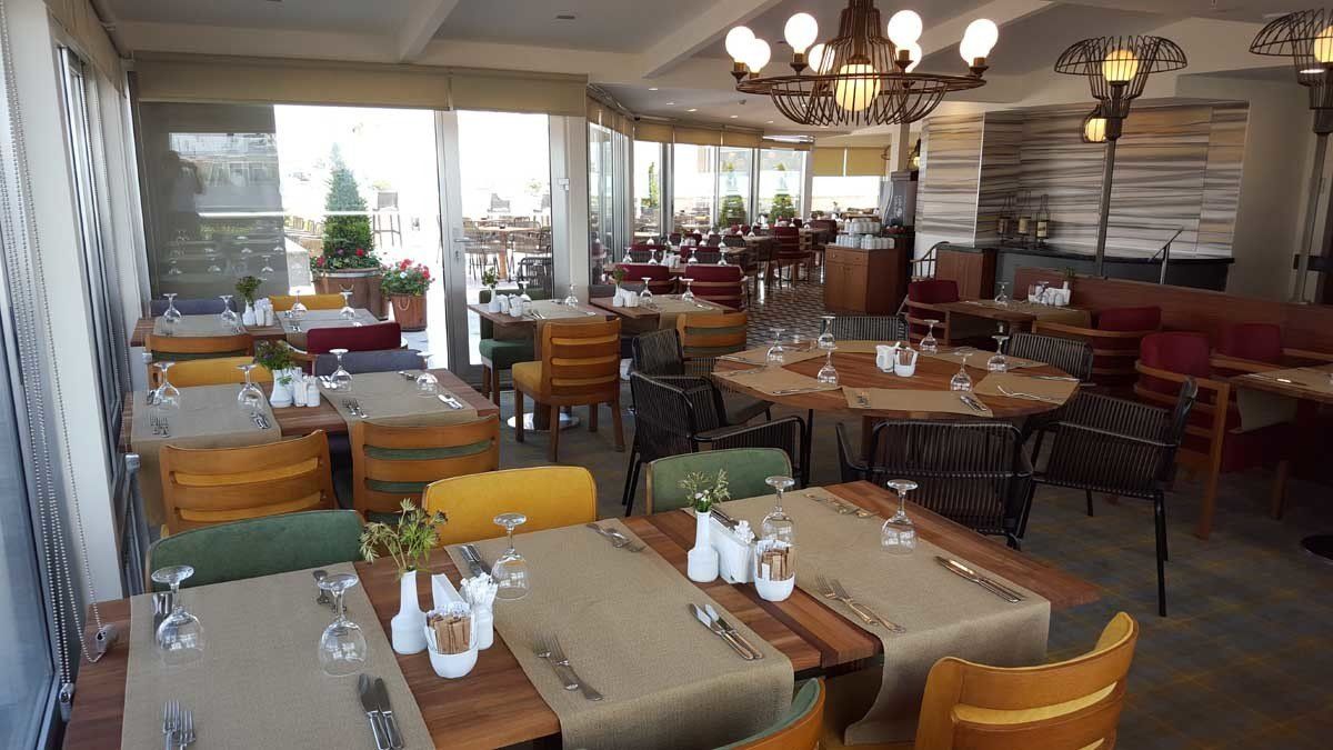 Yemek için hazırlanmış masa ve sandalyelerin bulunduğu restoran.