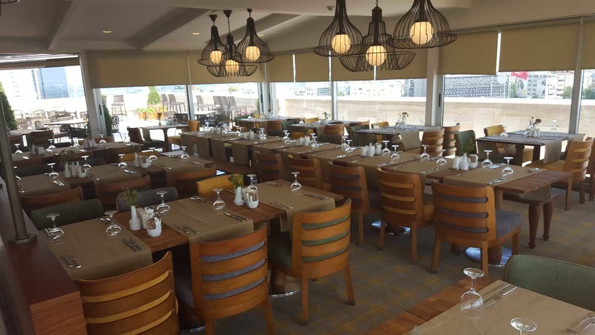 Yemek için hazırlanmış masa ve sandalyelerin bulunduğu restoran.