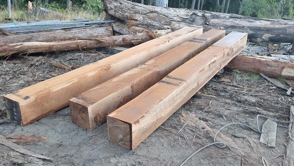 Three Logs Are Stacked On Top Of Each Other On The Ground — Eungella Sawmill In Crediton, QLD