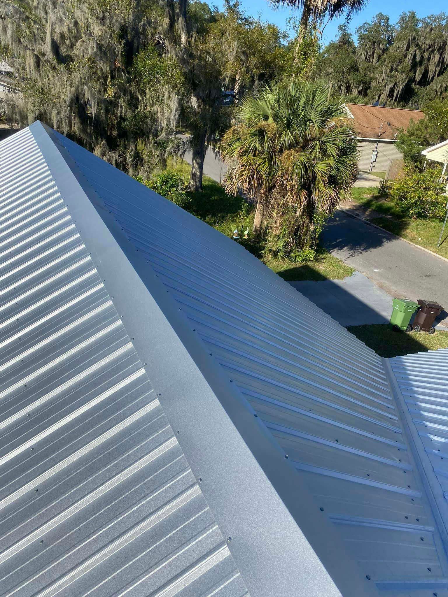 A close up of a metal roof with trees in the background.