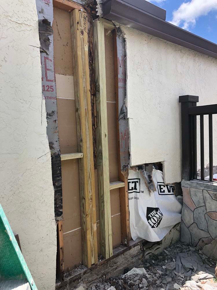 A wall with a hole in it is being demolished.