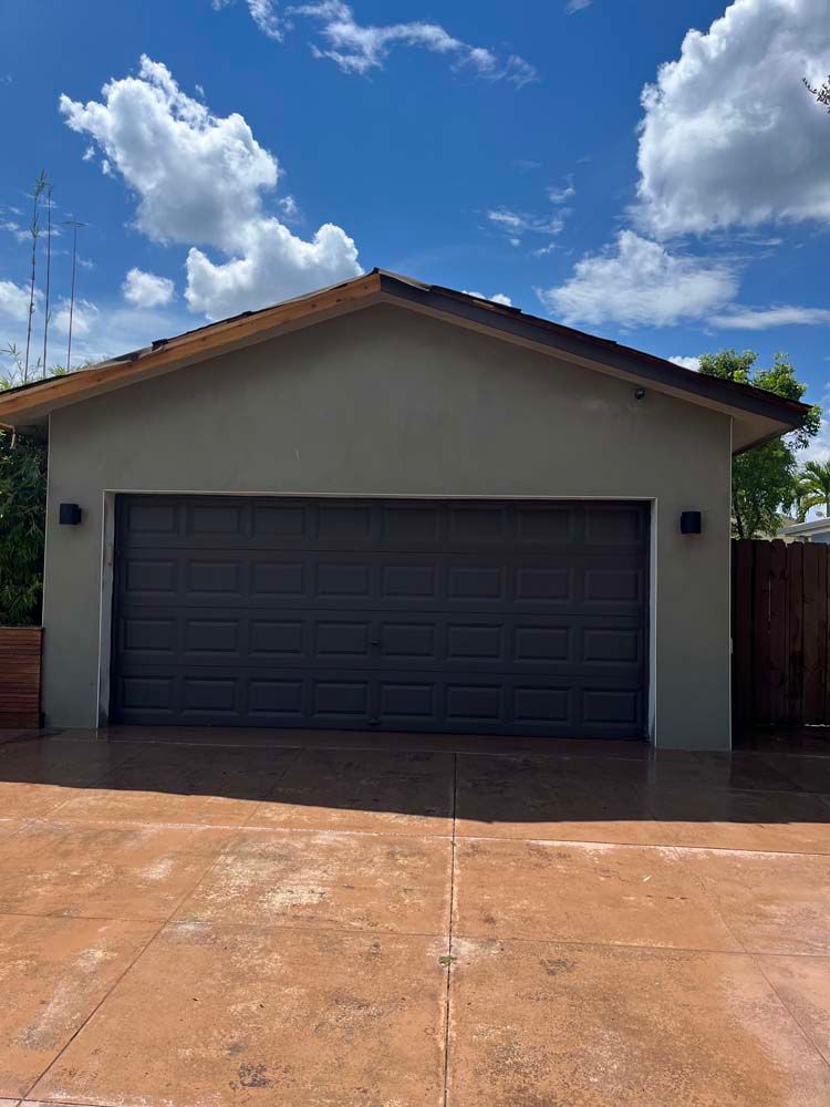 A garage with a gray garage door and a driveway in front of it.