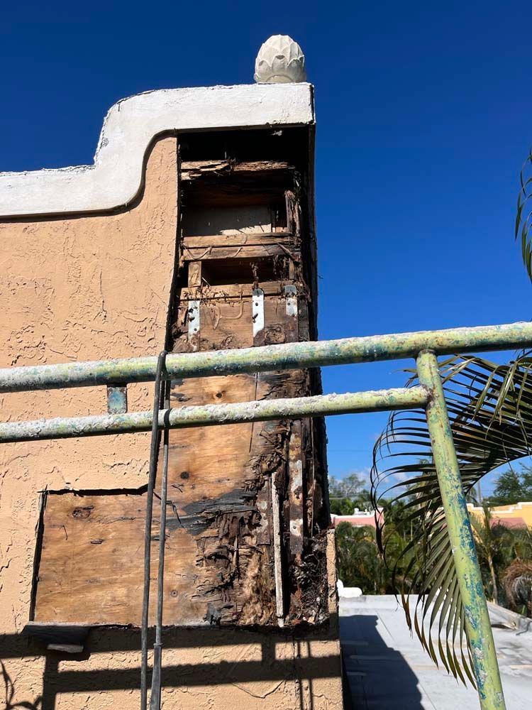 The side of a building with a fence in front of it.