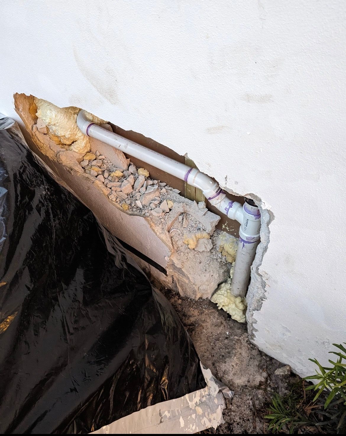 A hole in a wall with a pipe coming out of it