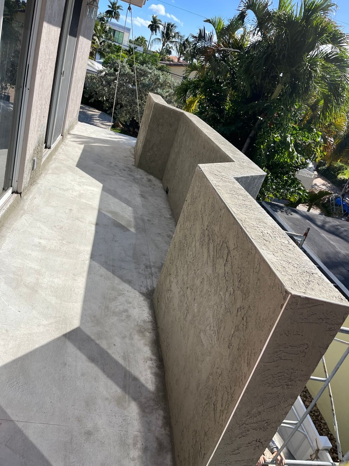 A balcony with a concrete wall and stairs leading up to it.