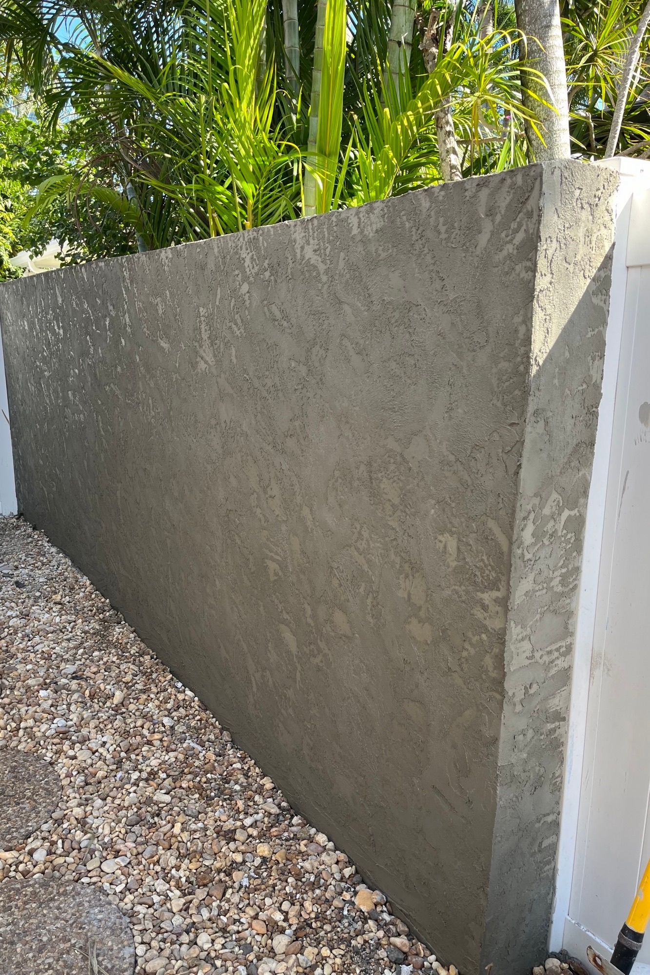 A concrete wall is being built next to a gravel path.