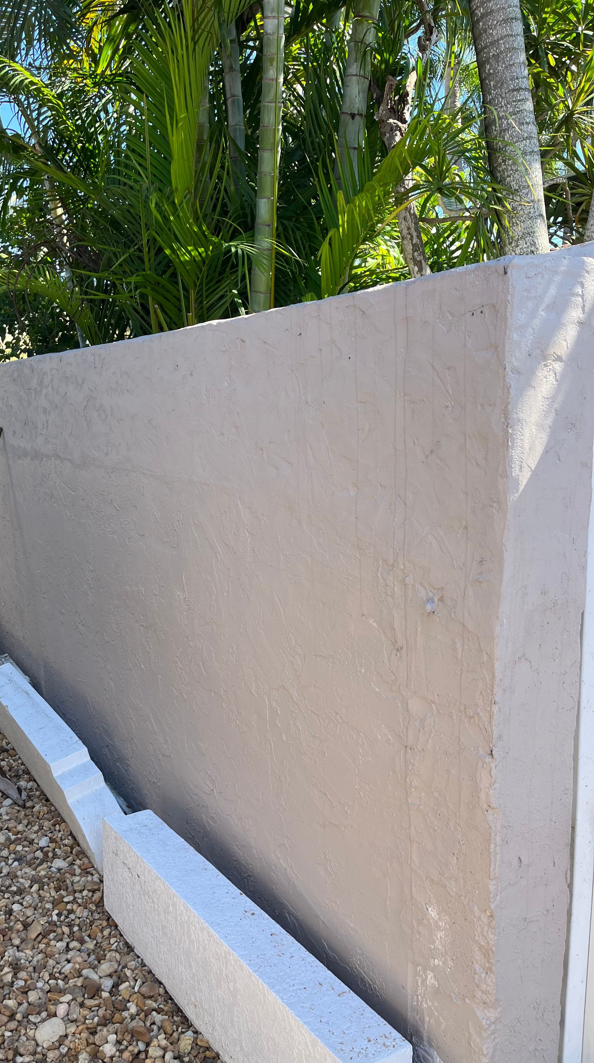 A close up of a concrete wall with trees in the background.