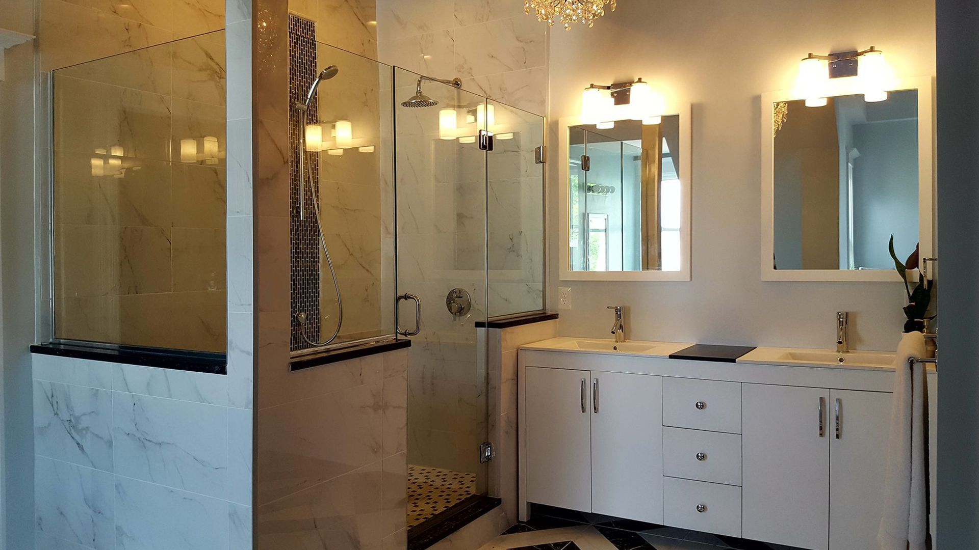 A bathroom with two sinks and a walk in shower.