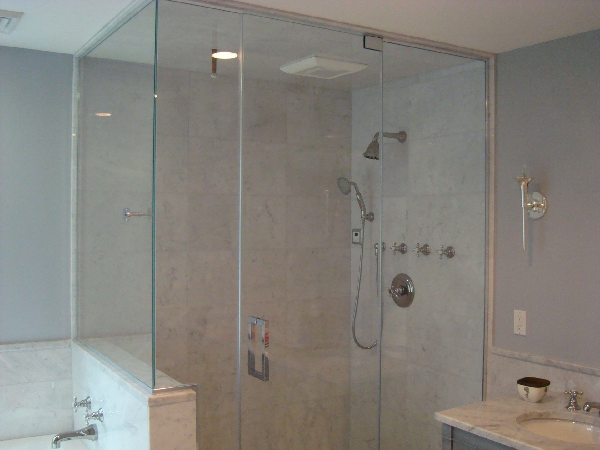 A bathroom with a walk in shower and a sink.