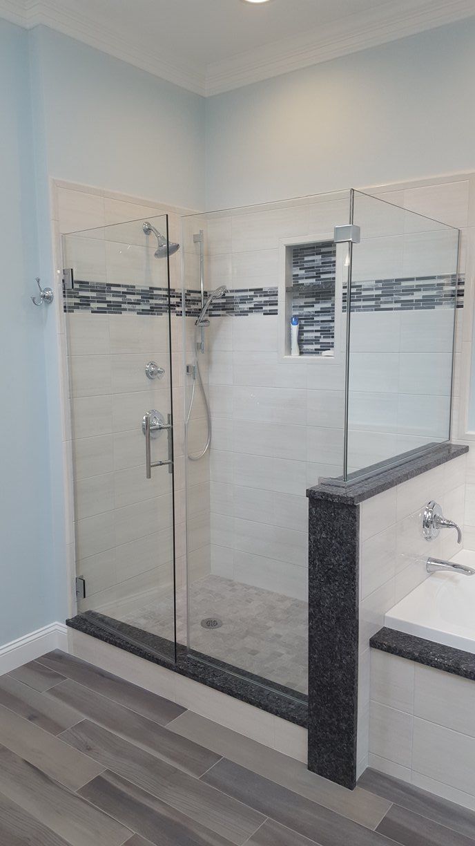 A bathroom with a walk in shower and a bathtub.