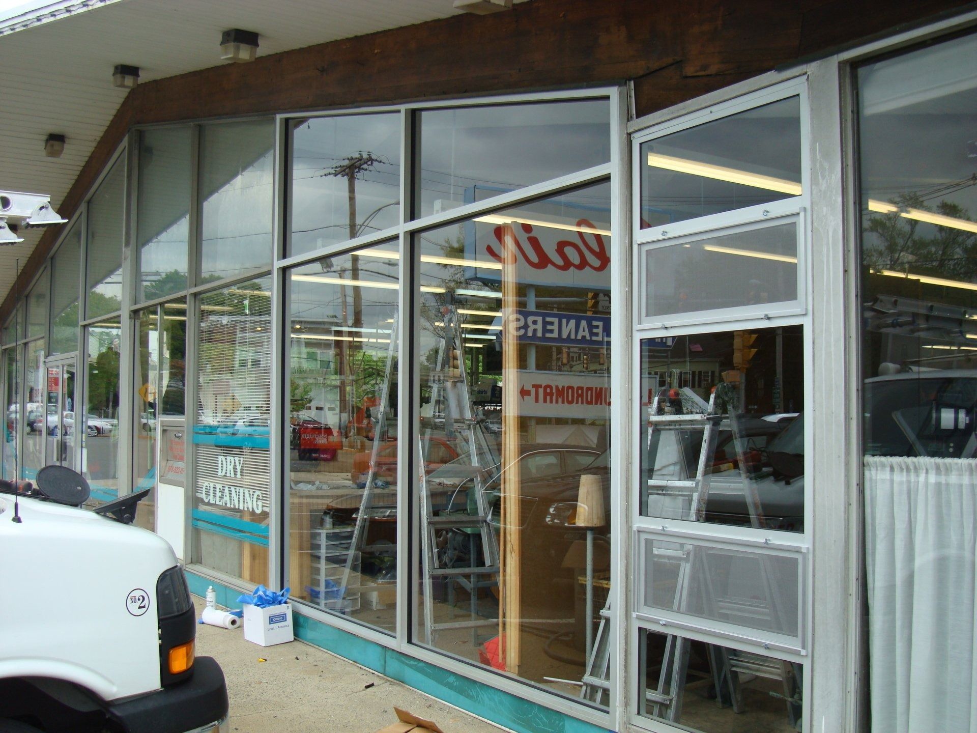 A white truck is parked in front of a store.