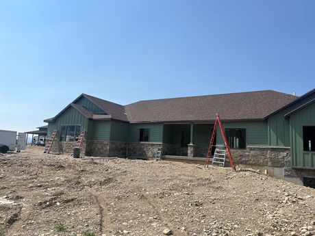 A house is being built in a dirt field with a ladder in front of it — Ogden, UT — Miller Siding