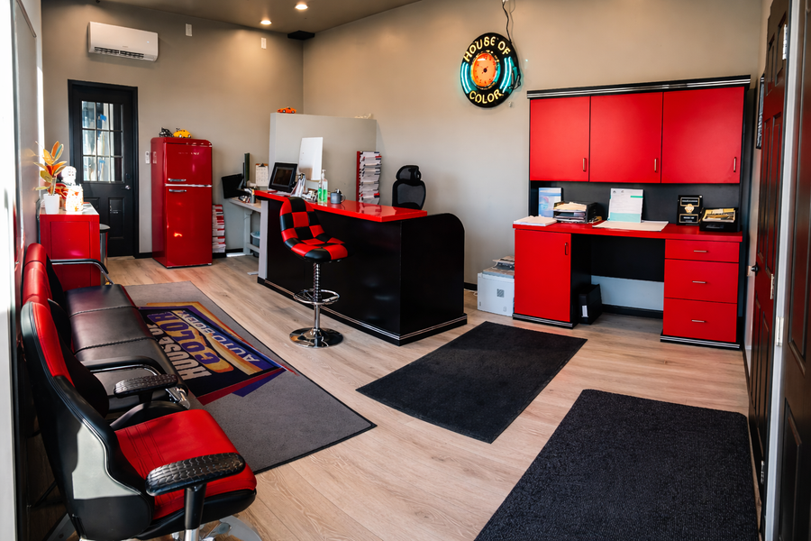 Reception area with red and black decor, desk, and cabinets. Includes a retro refrigerator and clock.