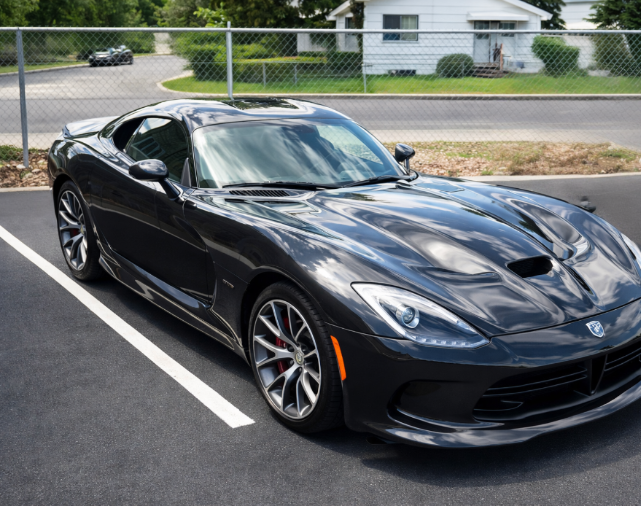 Dark gray Dodge Viper sports car parked in an asphalt lot.