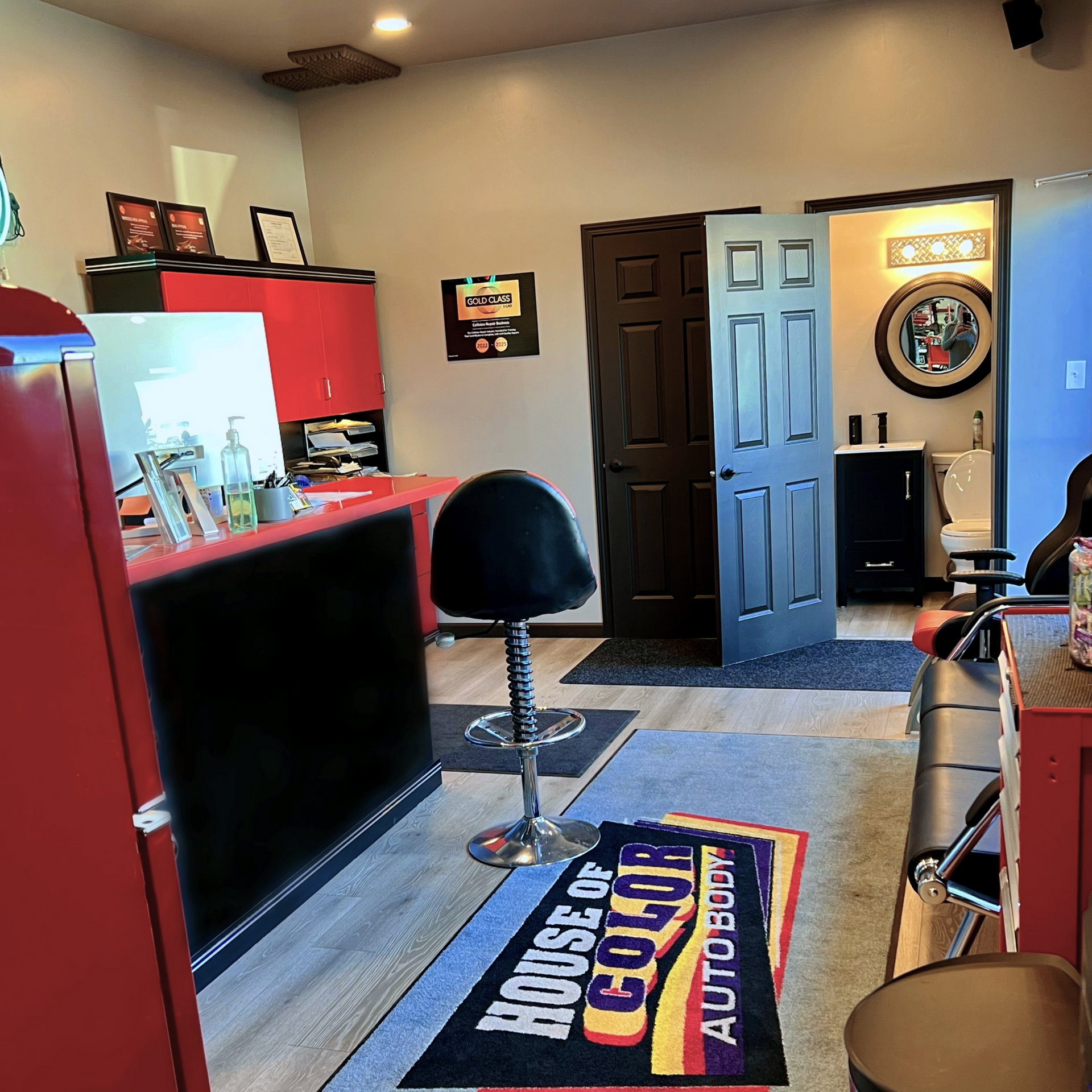 Interior of an auto body shop with a front desk, stool, doors, and a 