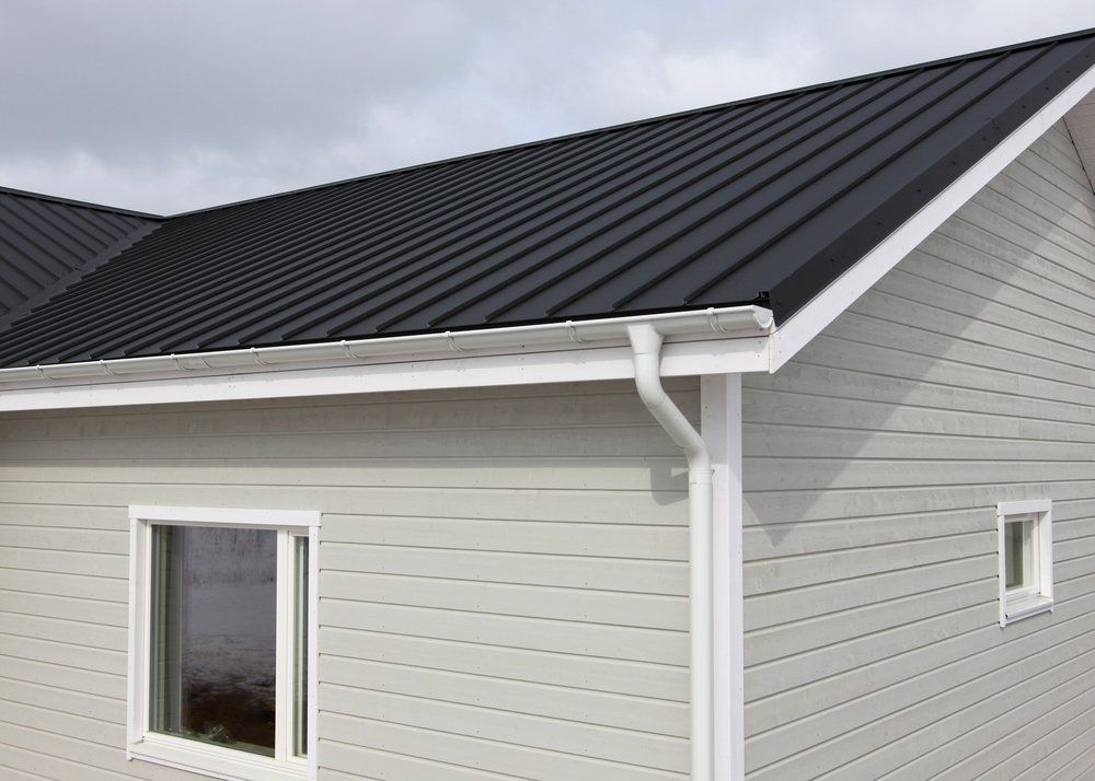 A House With a Black Roof and White Siding — Goulburn Roofing In Bowral, NSW