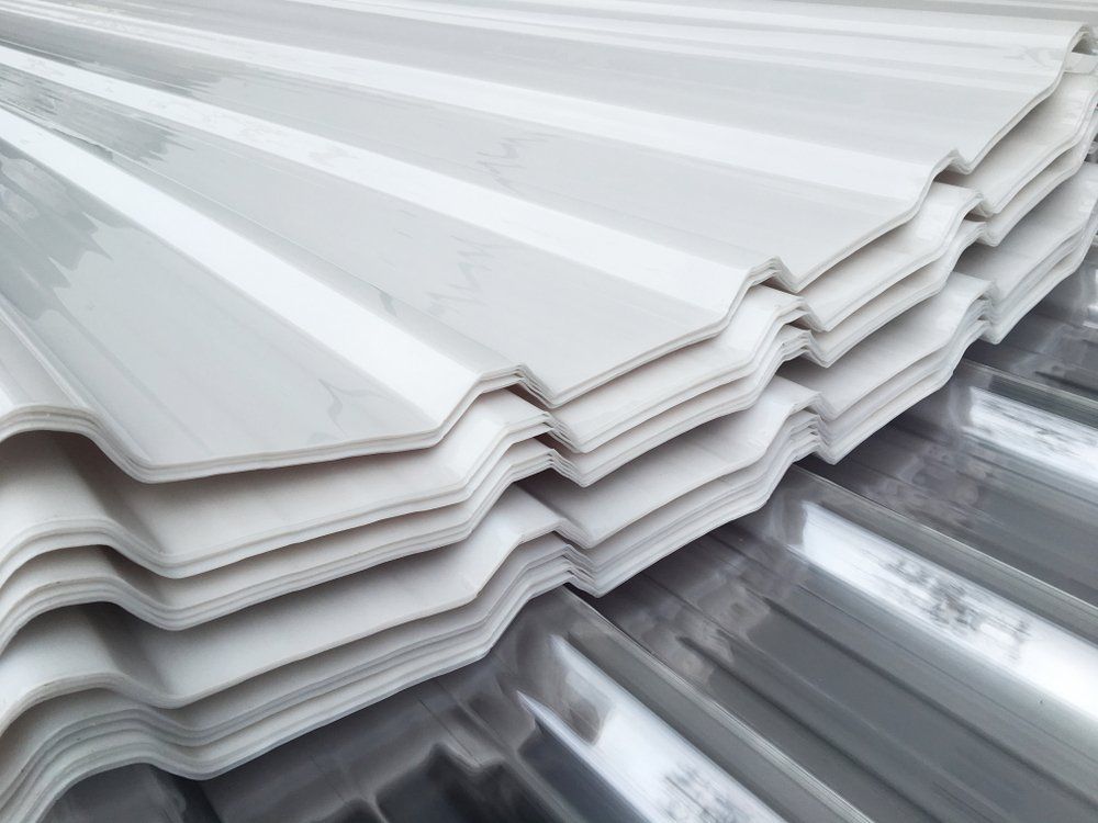 A Close Up of a Stack of White Corrugated Metal Sheets — Goulburn Roofing In Goulburn, NSW