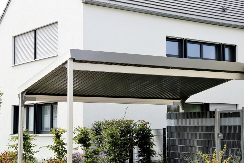 A White House With a Carport in Front of It — Goulburn Roofing In Goulburn, NSW
