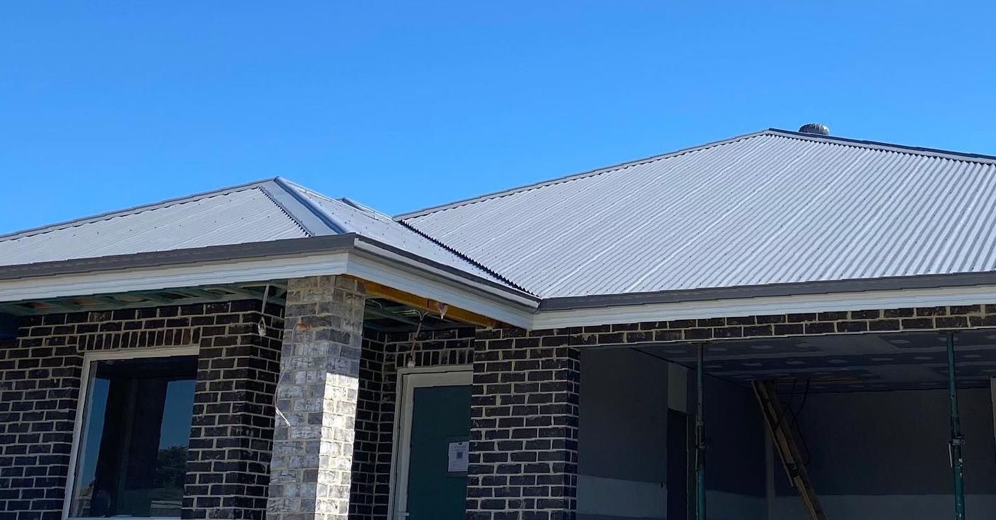 A Before and After Picture of a Brick House — Goulburn Roofing In Goulburn, NSW