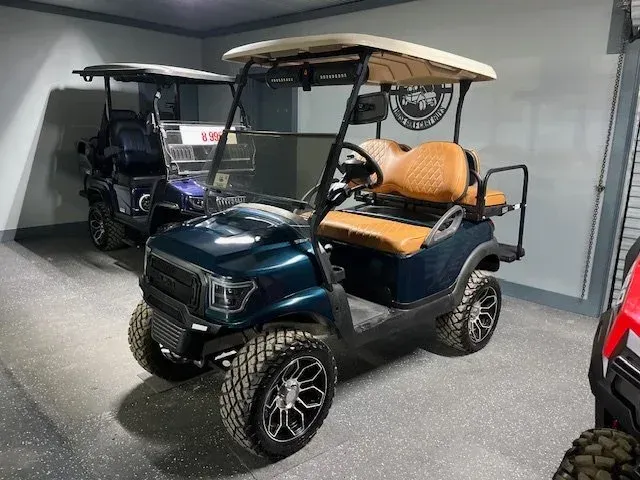 Dark teal golf cart with tan seats and roof, parked inside a garage.