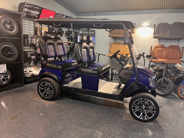 White golf cart with black accents, large tires, and windshield.