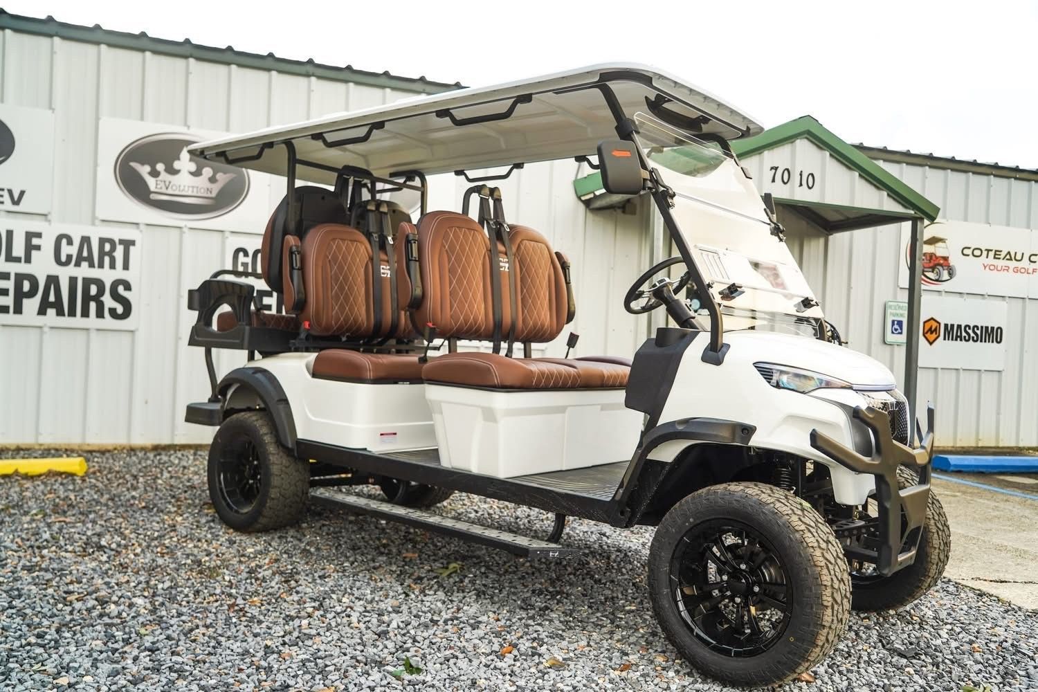 Black golf cart with a roof, four seats, and off-road tires on a white background
