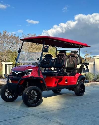 Black golf cart with a roof, four seats, and off-road tires on a white background