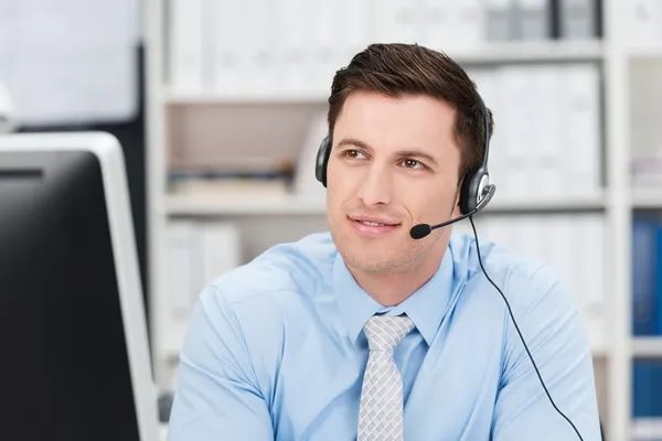 A man in a suit and tie is pressing a button on a virtual screen.