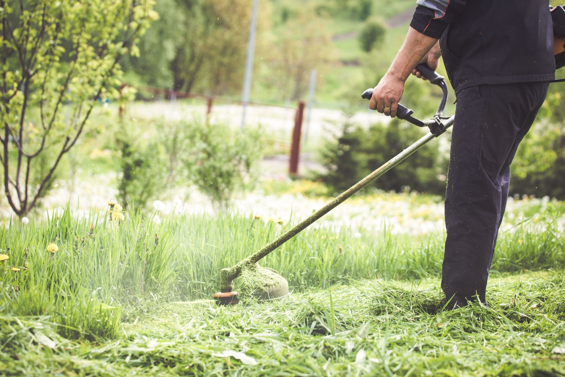 A man is mowing the grass with a lawn mower.