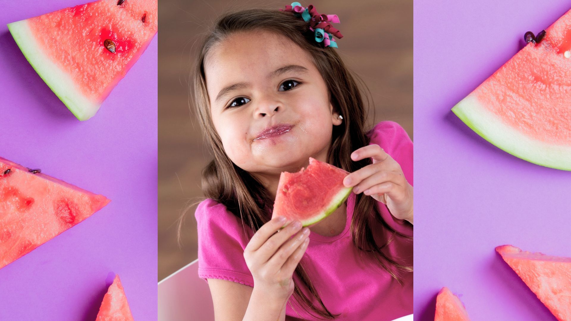 Picture of a little girl smiling and holding up a bitten slice of watermelon.