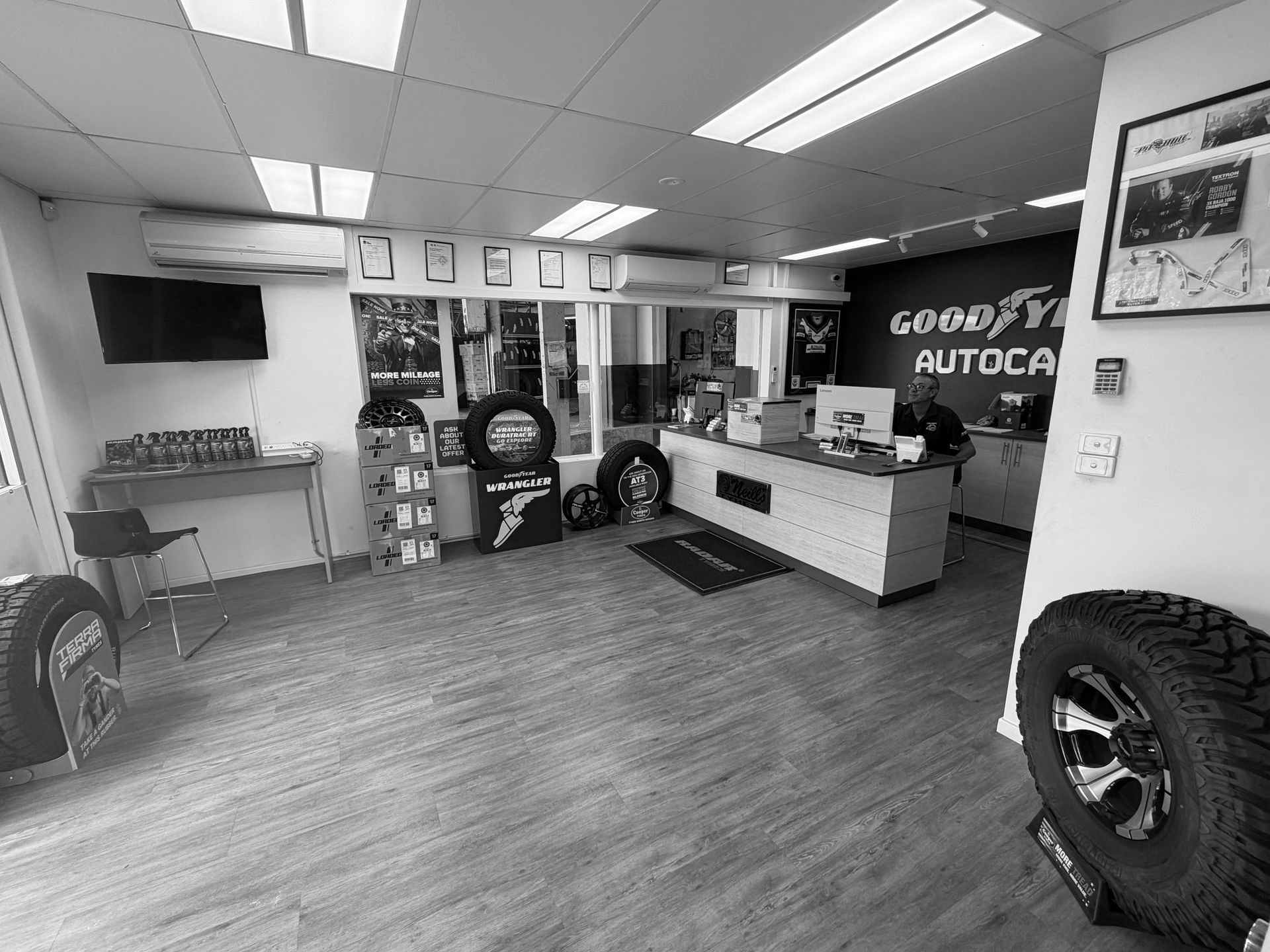 Interior view of a Goodyear Autocare service shop with a service counter, tires, and brand signage on the walls.