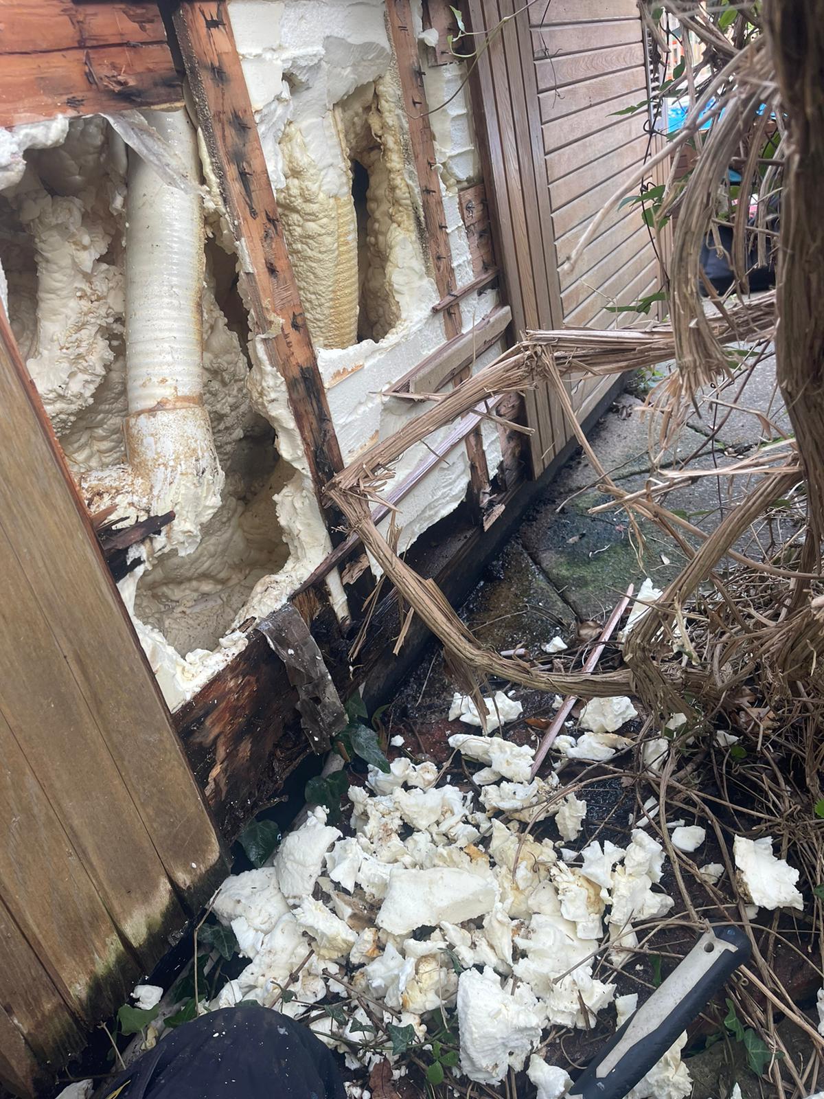 There is a lot of foam coming out of the wall of a building.